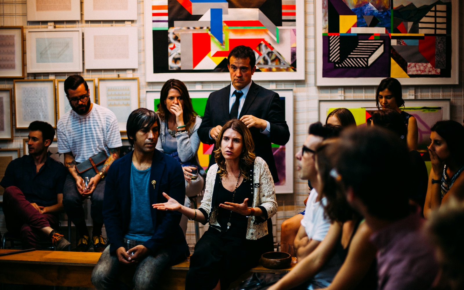 A members’ evening in The Gallery at Meridian Lisbon, with the print wall behind the speaker